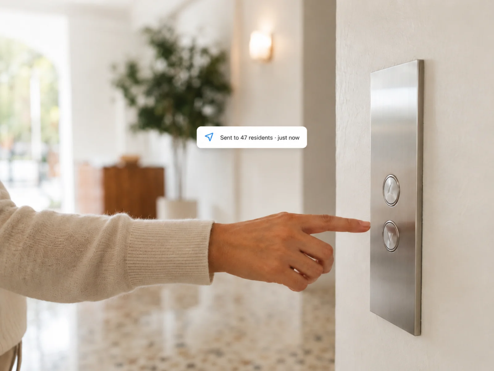 A hand reaching for an elevator panel with a sent-to-47-residents chip